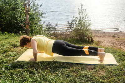 Rear view of woman relaxing on grass