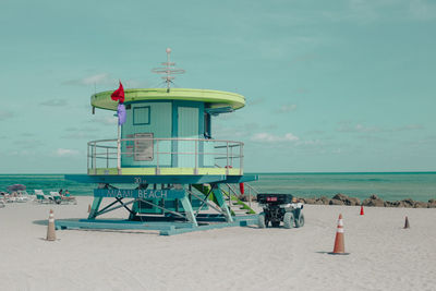 Lifeguard hut on beach against sky