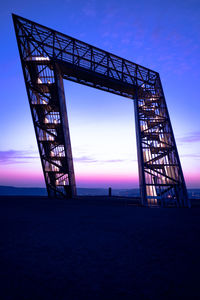 Low angle view of silhouette bridge against sky during sunset