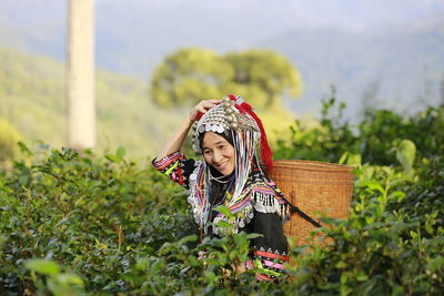 Portrait of young woman holding plant