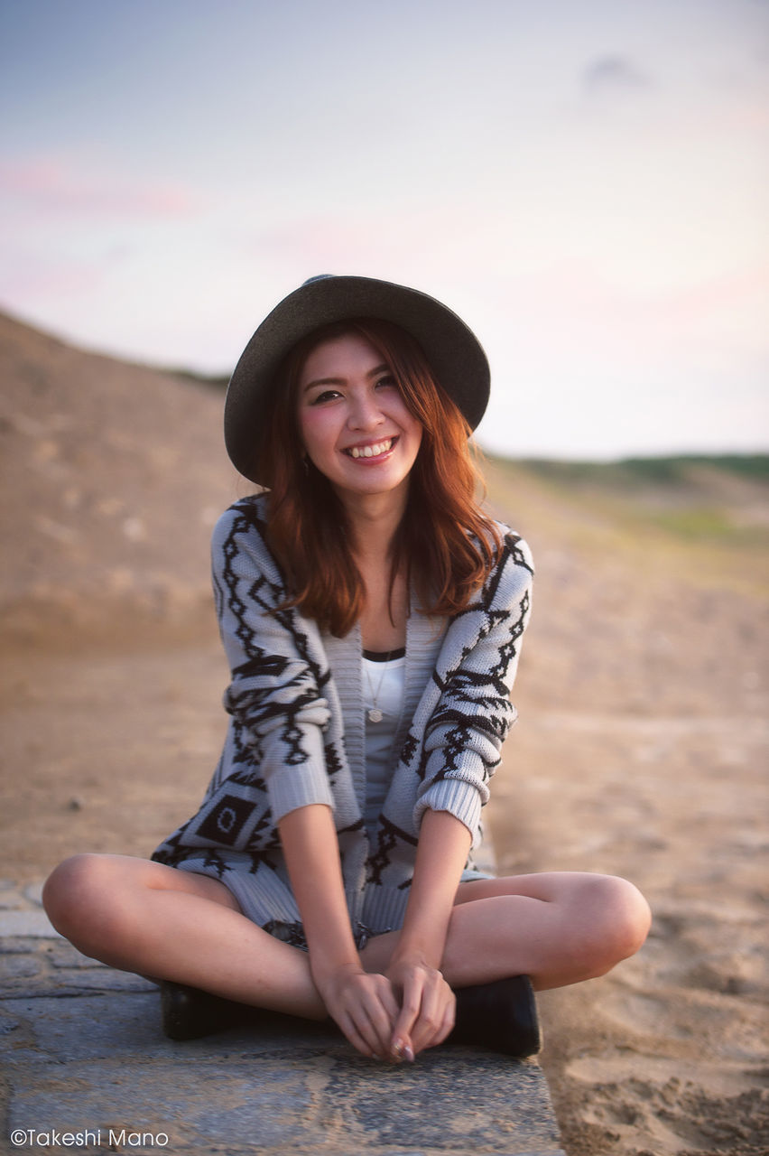 portrait, person, looking at camera, young adult, lifestyles, young women, leisure activity, front view, smiling, casual clothing, standing, happiness, focus on foreground, sunglasses, long hair, beach, three quarter length