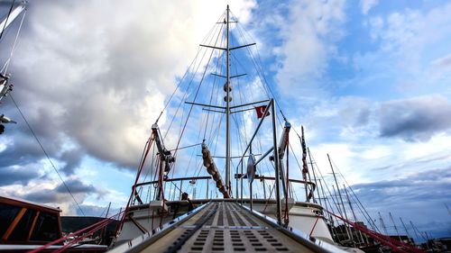 Low angle view of mast against cloudy sky