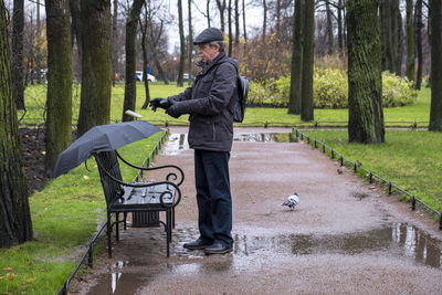 Side view of a man standing on footpath