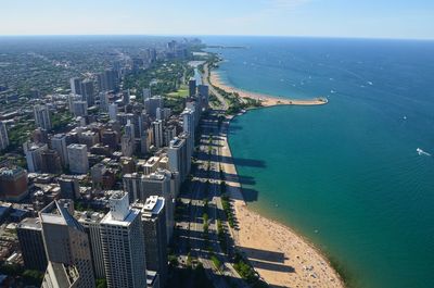 Aerial view of city by sea against sky