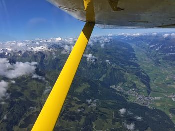 Airplane flying over landscape against sky