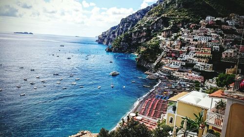 Positano village by sea against sky