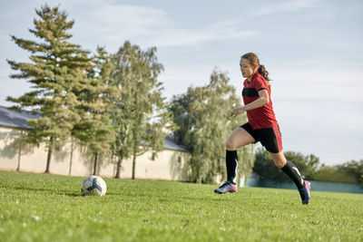 Girl practicing soccer on sports field