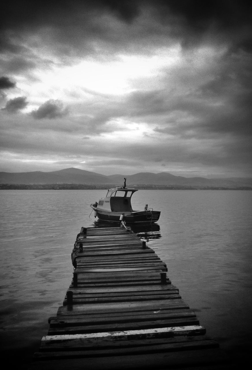 water, sky, pier, sea, nautical vessel, boat, tranquil scene, tranquility, jetty, cloud - sky, wood - material, transportation, scenics, nature, beauty in nature, cloudy, horizon over water, mode of transport, the way forward, moored