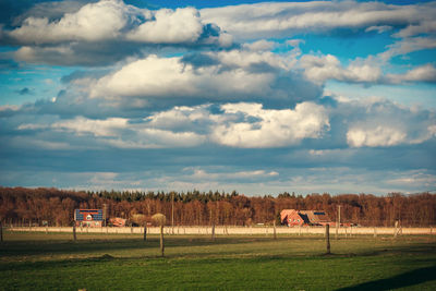 Scenic view of grassy field against cloudy sky