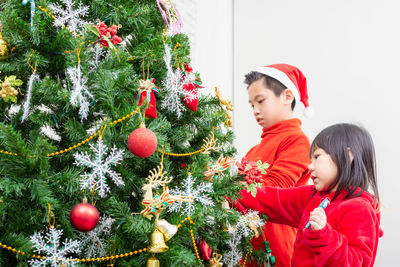 Full length of mother with christmas tree