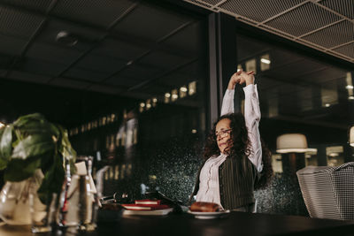 Woman stretching in office at night