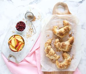 High angle view of croissant and fruits on table