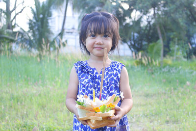 Portrait of young woman standing against plants