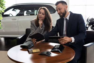 Sales colleague discussing in car showroom