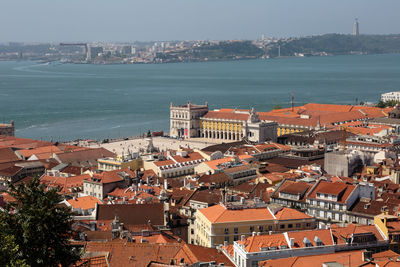 High angle view of townscape by sea against sky