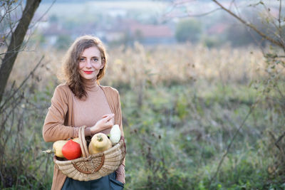 Portrait of a smiling young woman holding basket