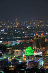 Illuminated cityscape against sky at night