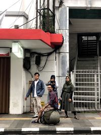 People on street against buildings in city