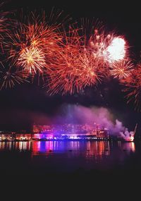 Firework display over river at night