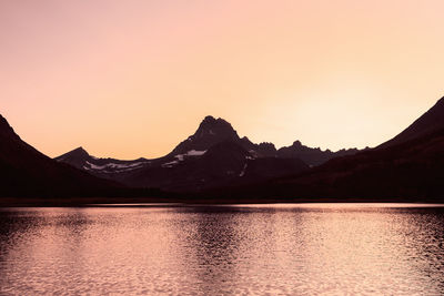 Scenic view of lake against clear sky during sunset