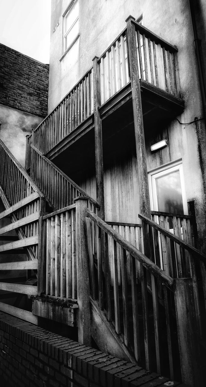 architecture, built structure, staircase, black and white, building exterior, railing, black, steps and staircases, monochrome, building, monochrome photography, stairs, white, low angle view, house, no people, window, fire escape, darkness, urban area, residential district, old, day, street, abandoned, city, outdoors