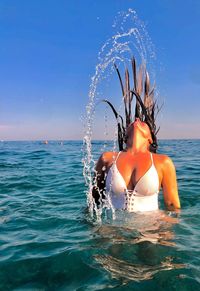 Man splashing water in sea against sky