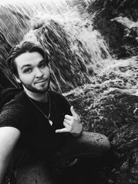 Portrait of smiling young man on rock