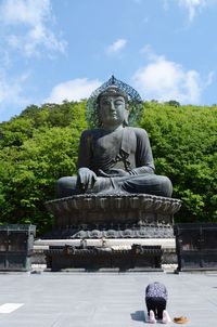 Statue of buddha against cloudy sky