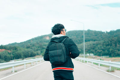 Rear view of man standing on road