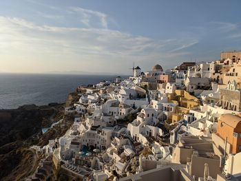 High angle view of townscape by sea against sky