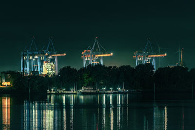 Cranes by lake at night