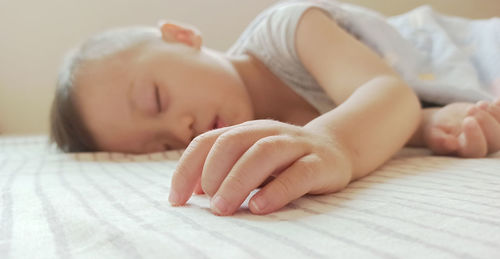 Close-up of baby sleeping on bed