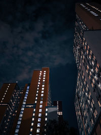 Low angle view of modern buildings against sky at night