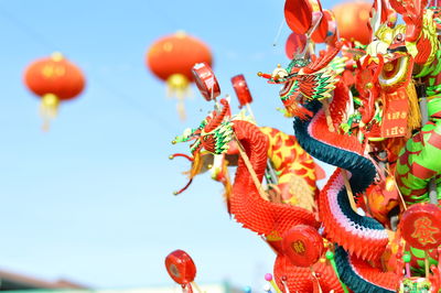 Close-up of chinese dragon paper doll at store against clear blue sky