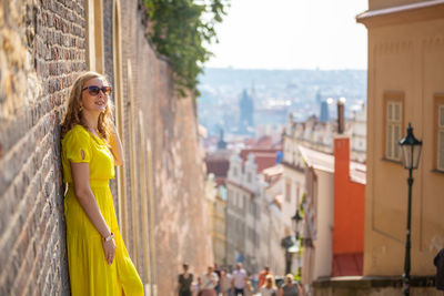 Woman in yellow dress traveling in city