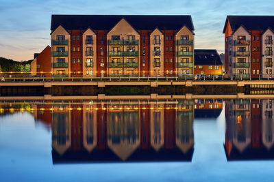 Reflection of building in river against sky