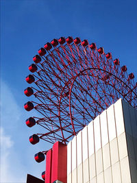 Low angle view of ferris wheel against blue sky