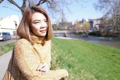 Woman with yellow knits by the park