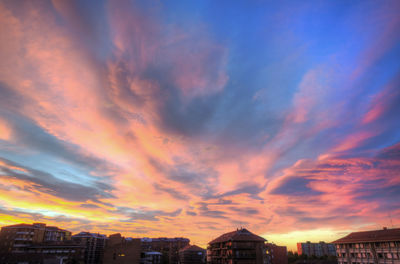 Buildings against cloudy sky at sunset