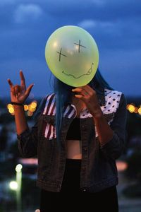 Midsection of man with balloons against sky