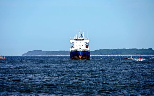 Ship sailing on sea against clear sky