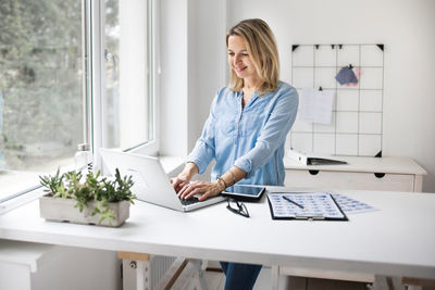 Smiling businesswoman working at office