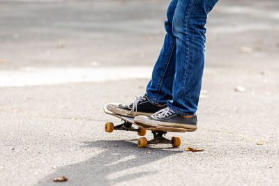 Low section of person skateboarding on road