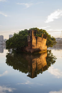 Reflection of building on lake against sky