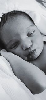 Close-up of baby sleeping on bed