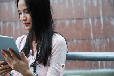 Woman looking away while using mobile phone