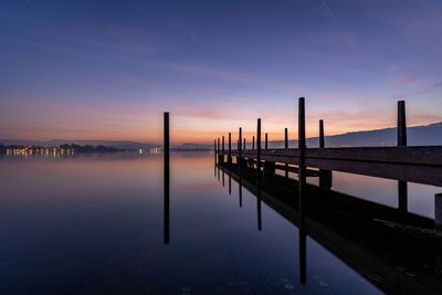 Pier over lake against sunrise 