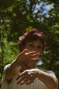 Portrait of smiling woman against trees