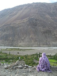 Rear view of a woman with mountain range in the background