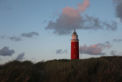 Lighthouse by sea against sky